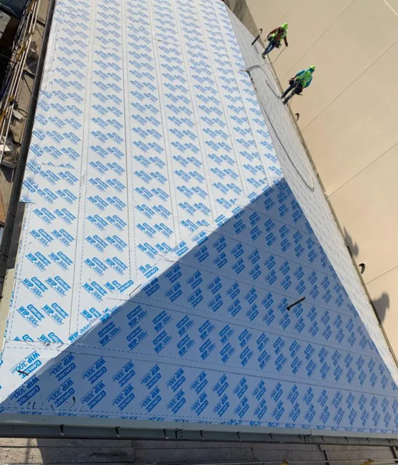 Professional roofers installing underlayment on a metal roof in Lower Makefield